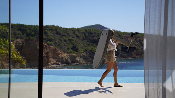 Woman carrying ULTRA L eFoil near pool overlooking ocean