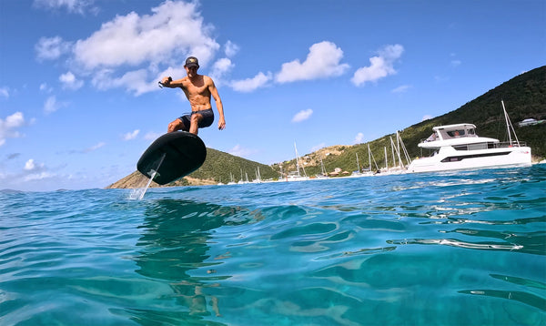 James Jenkins riding a Fliteboard near a yacht in the British Virgin Islands